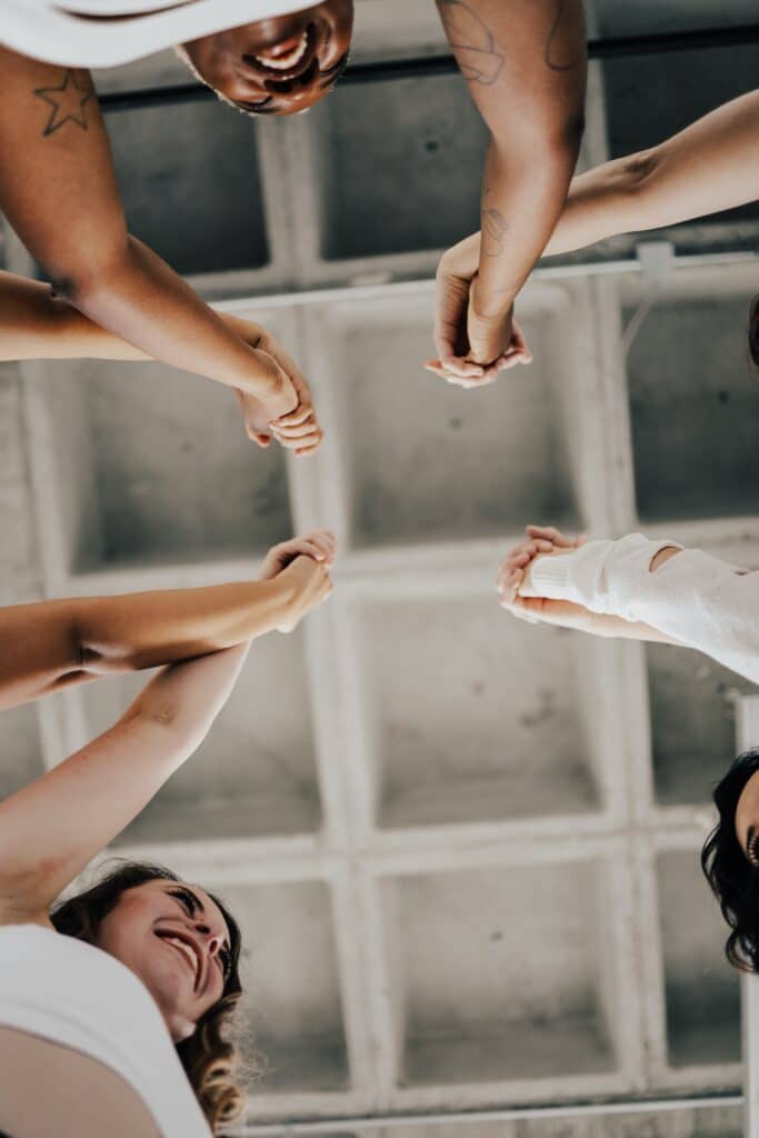 People with their hands together building community